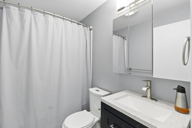 bathroom with toilet, vanity, and curtained shower