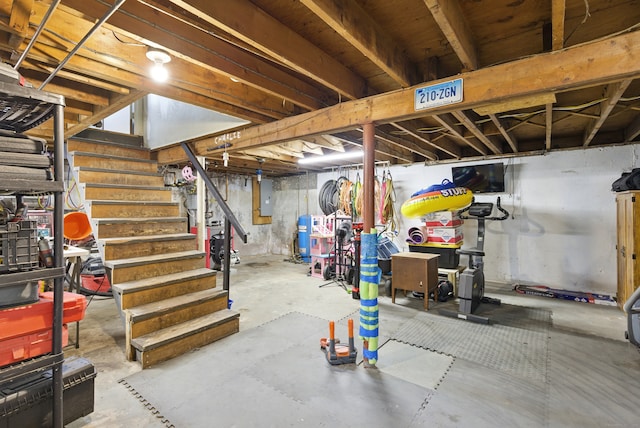unfinished below grade area featuring stairway and electric panel