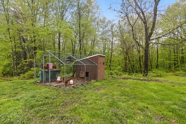 view of green lawn with exterior structure and an outbuilding