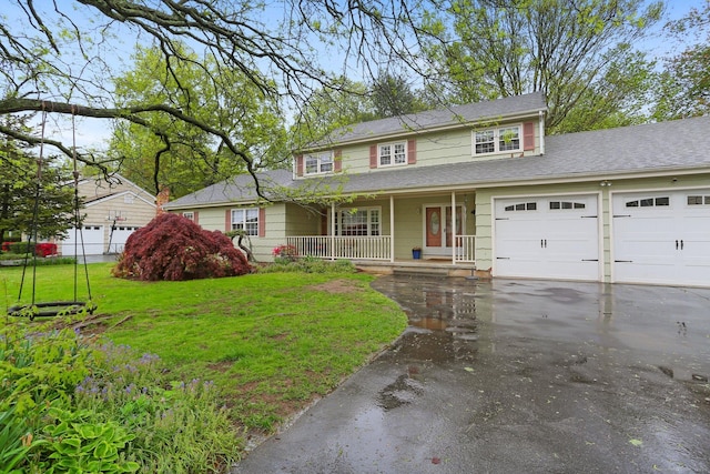 traditional-style home with a porch, asphalt driveway, an attached garage, and roof with shingles