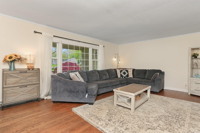 living area with crown molding, wood finished floors, and baseboards