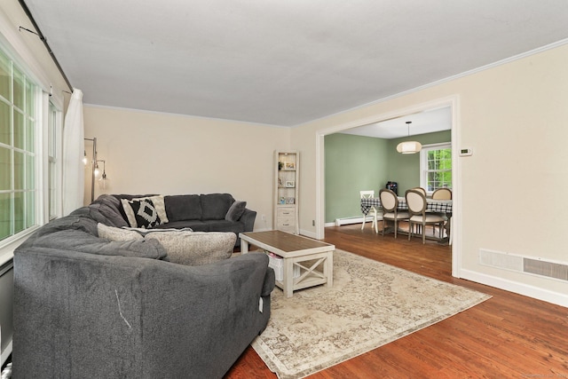 living room featuring dark wood finished floors, baseboards, and ornamental molding