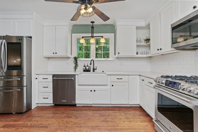 kitchen featuring appliances with stainless steel finishes, a sink, a ceiling fan, white cabinets, and light countertops