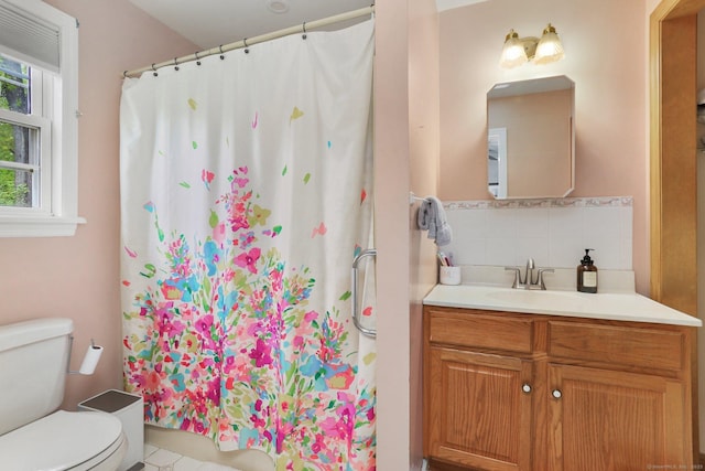 bathroom with toilet, curtained shower, backsplash, and vanity