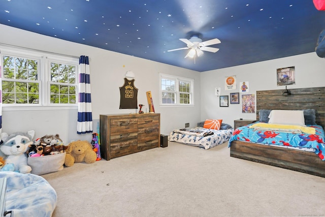 carpeted bedroom with multiple windows and ceiling fan