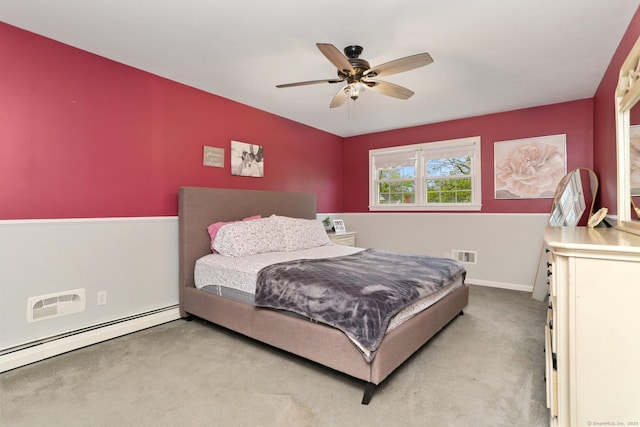bedroom with a baseboard heating unit, carpet, baseboards, and ceiling fan