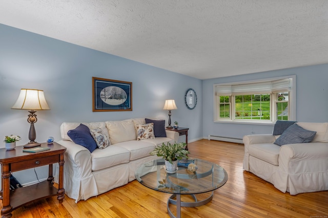 living room featuring a baseboard radiator, wood finished floors, a textured ceiling, and baseboards