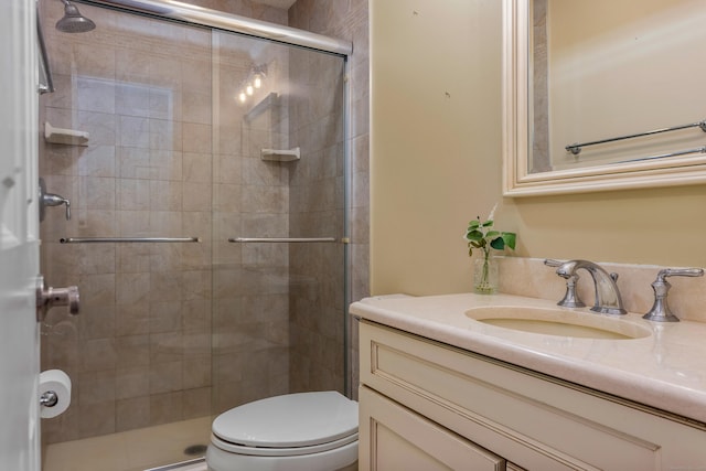 full bath featuring a stall shower, toilet, and vanity
