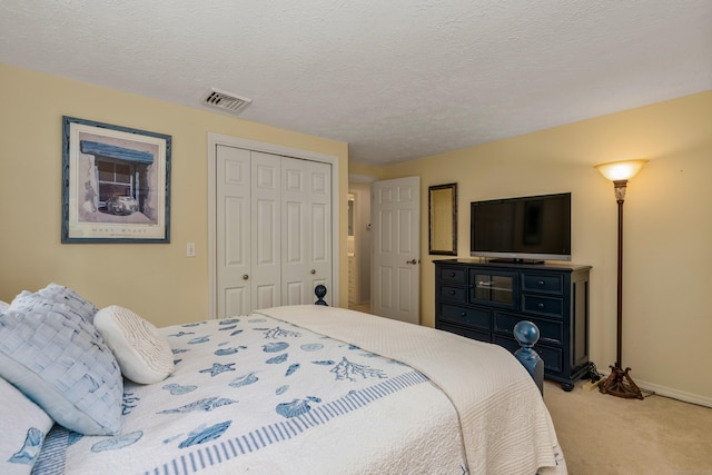 bedroom with carpet, a closet, a textured ceiling, and baseboards