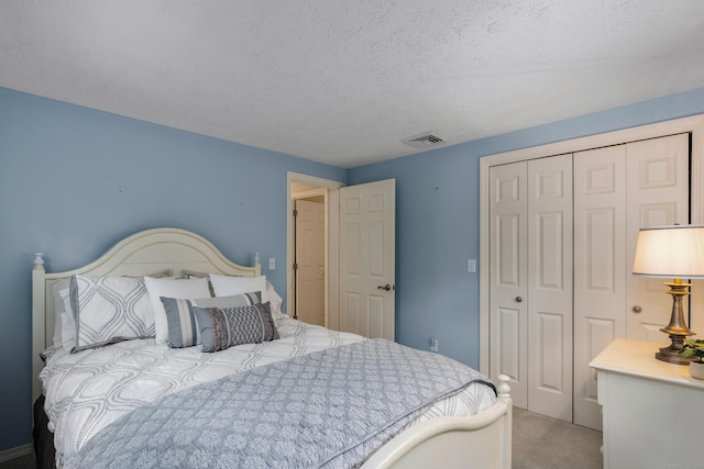 carpeted bedroom with a closet and a textured ceiling