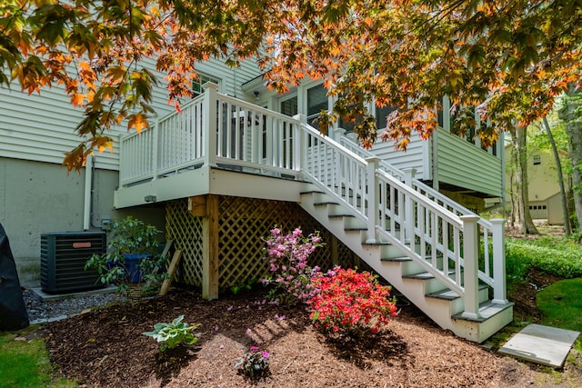 view of side of property with central air condition unit, stairway, and a wooden deck