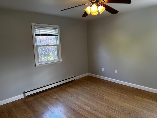 unfurnished room featuring a baseboard heating unit, wood finished floors, baseboards, and a ceiling fan
