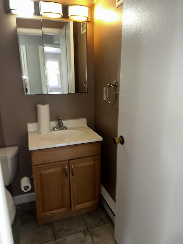 half bathroom with toilet, vanity, and tile patterned floors