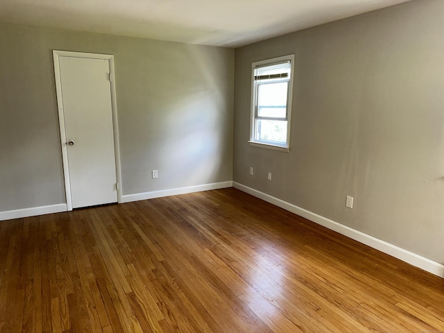 unfurnished room featuring hardwood / wood-style flooring and baseboards