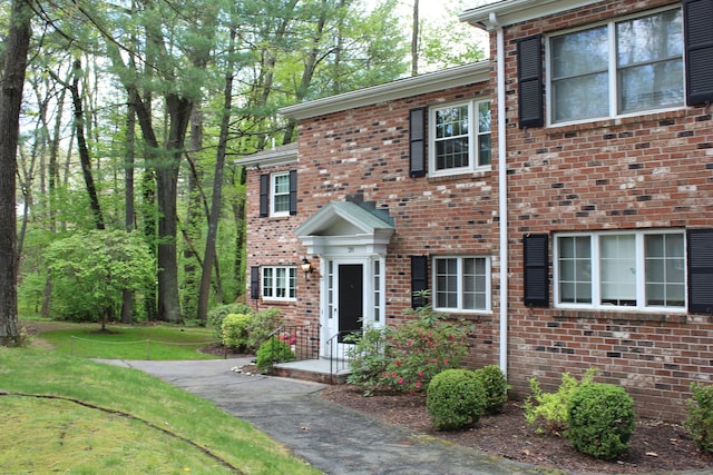 view of front of property featuring brick siding and a front yard