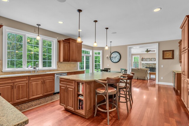 61 Governors Way, Madison, CT 06443 - kitchen with stainless steel dishwasher, a sink, light wood-style floors, a fireplace, and recessed lighting