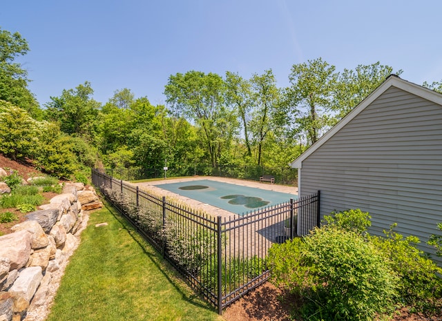 view of swimming pool with a jacuzzi and fence