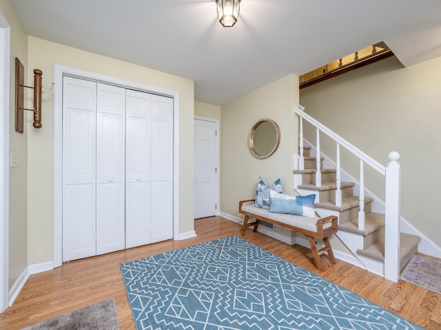 entryway featuring stairway, wood finished floors, and baseboards