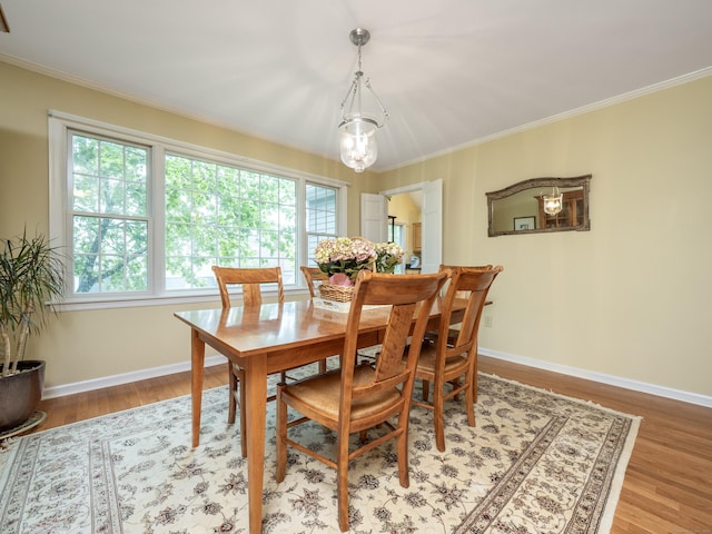dining room featuring ornamental molding, light wood-style floors, and baseboards