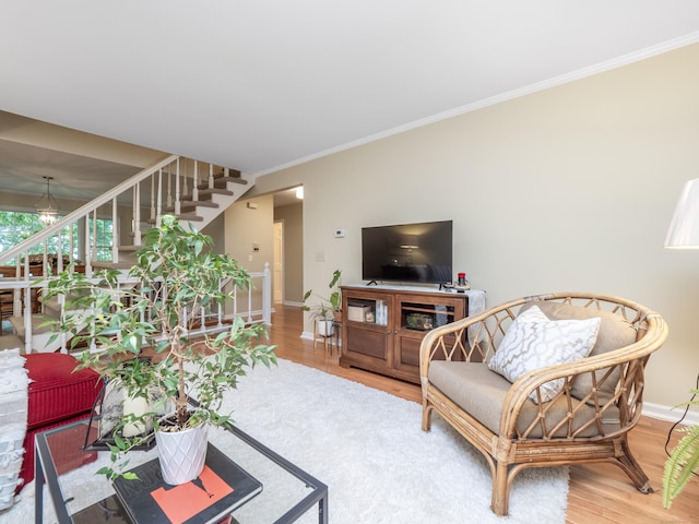 living room with stairway, wood finished floors, baseboards, and ornamental molding
