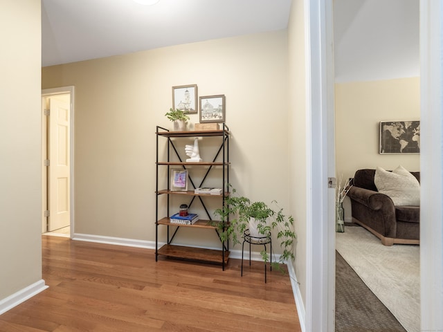 hallway with wood finished floors and baseboards