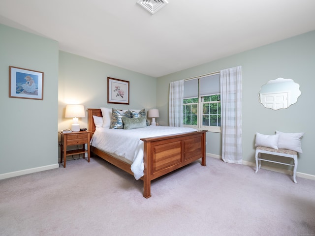 bedroom with light carpet and baseboards