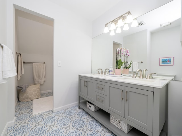 bathroom with double vanity and baseboards