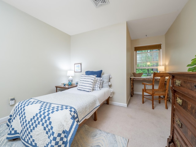 carpeted bedroom featuring baseboards and a desk