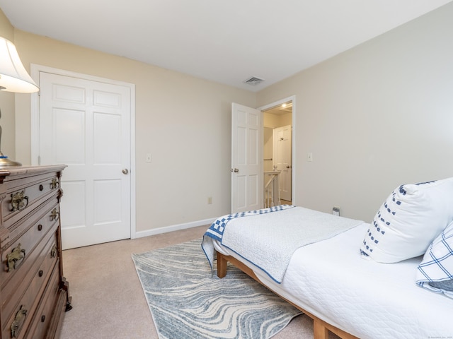 bedroom with light carpet and baseboards