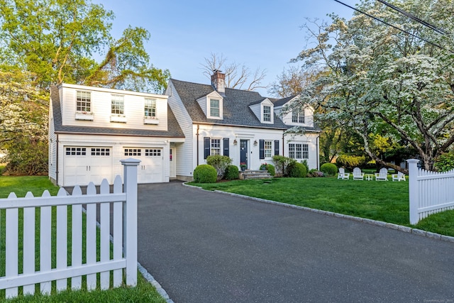 cape cod home with driveway, an attached garage, and a chimney