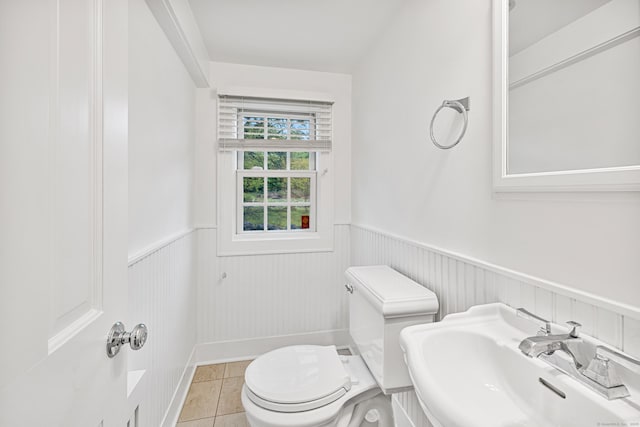 bathroom featuring a sink, wainscoting, toilet, and tile patterned floors