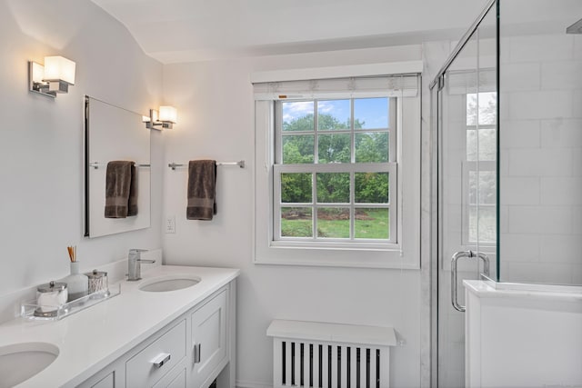 full bath featuring radiator, a stall shower, and double vanity