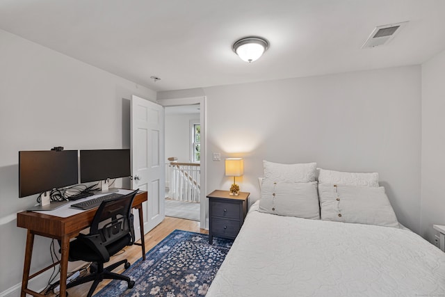bedroom featuring light wood-style flooring, a desk, and baseboards