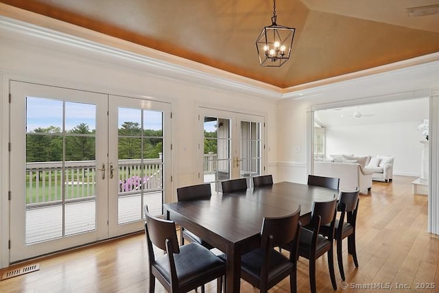 2 Aspetuck Hill Ln, Weston, CT 06883 - dining space featuring french doors, a tray ceiling, a chandelier, light wood-style flooring, and crown molding