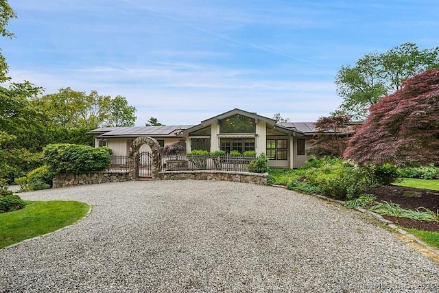 2 Aspetuck Hill Ln, Weston, CT 06883 - view of front of house featuring gravel driveway, a gate, and solar panels