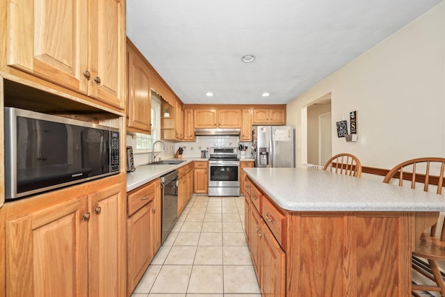 108 Fox Den Rd, Bristol, CT 06010 - kitchen featuring stainless steel appliances, a kitchen breakfast bar, a sink, under cabinet range hood, and light tile patterned flooring