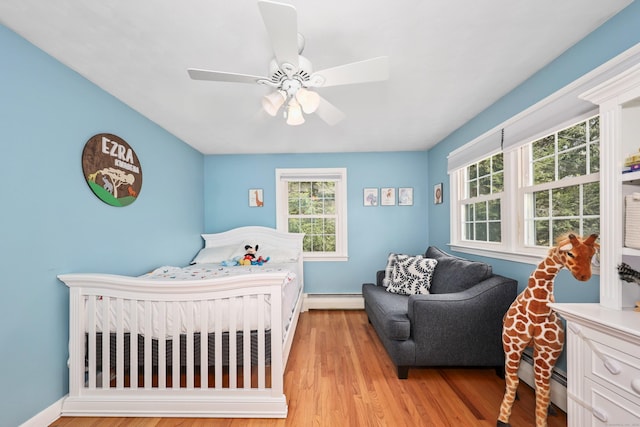 108 Fox Den Rd, Bristol, CT 06010 - bedroom with multiple windows, a baseboard radiator, and light wood-style flooring