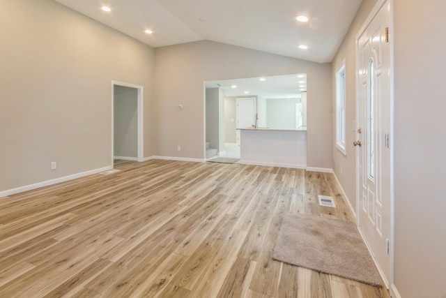spare room with light wood-style flooring, lofted ceiling, baseboards, and recessed lighting