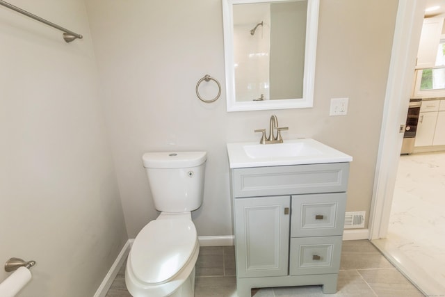 full bathroom featuring toilet, vanity, a shower, and baseboards