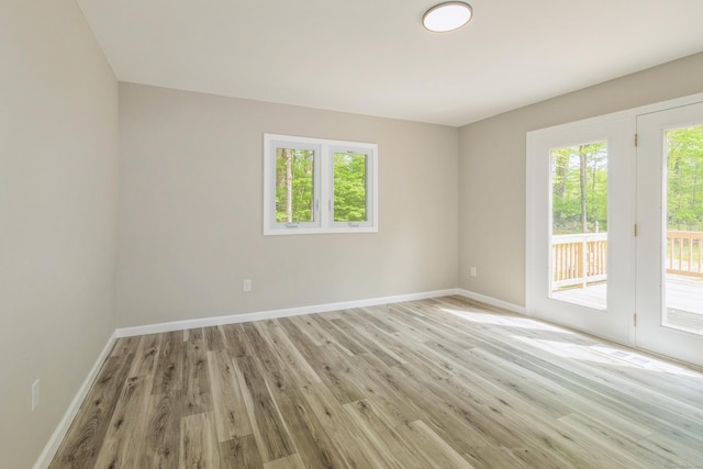 unfurnished room featuring baseboards and light wood-style flooring