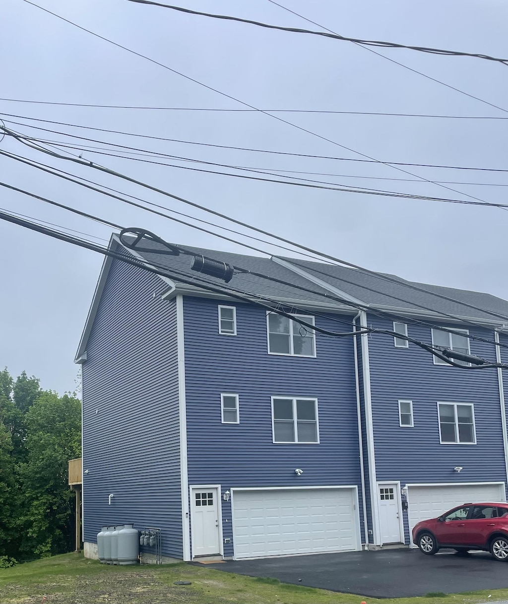 view of home's exterior with a garage and asphalt driveway