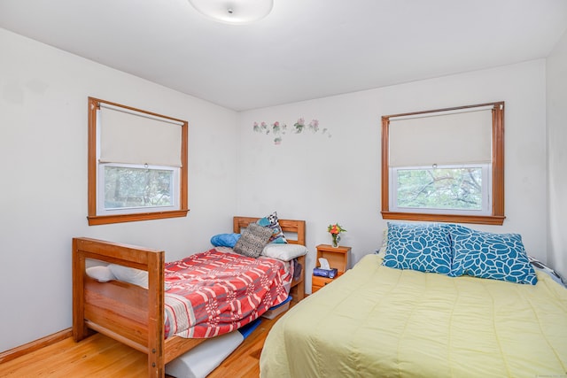 bedroom featuring multiple windows and wood finished floors