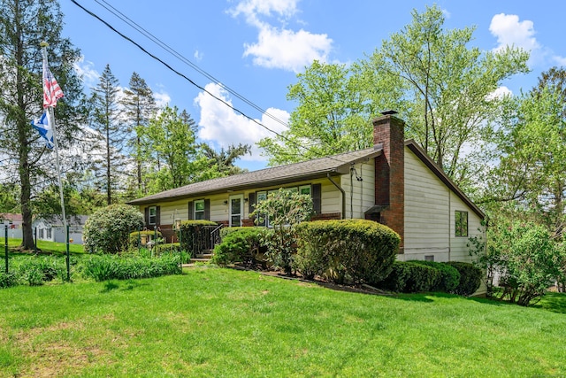 view of front of house featuring a chimney and a front yard