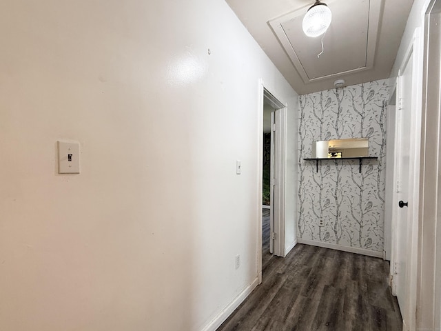 hall with attic access, wallpapered walls, dark wood-style floors, and baseboards