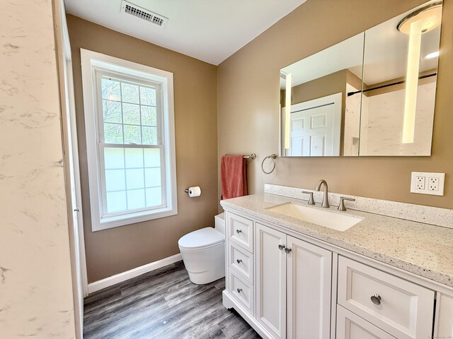 bathroom featuring wood finished floors, vanity, toilet, and baseboards
