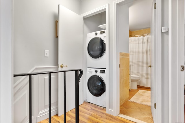 30 Elmcroft Rd Apt 12, Stamford, CT 06902 - laundry area with stacked washer / drying machine, a wainscoted wall, and light tile patterned flooring