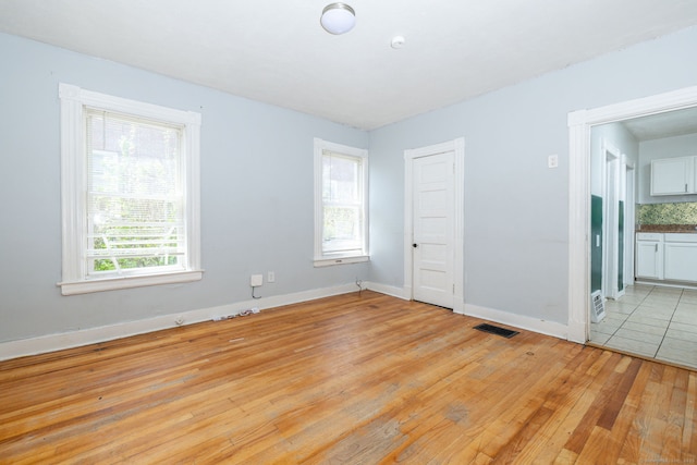 empty room featuring light wood-type flooring and baseboards