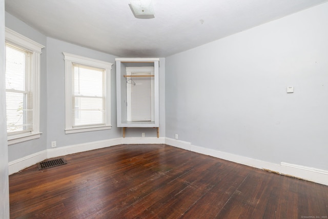 unfurnished room featuring wood finished floors, baseboards, and plenty of natural light