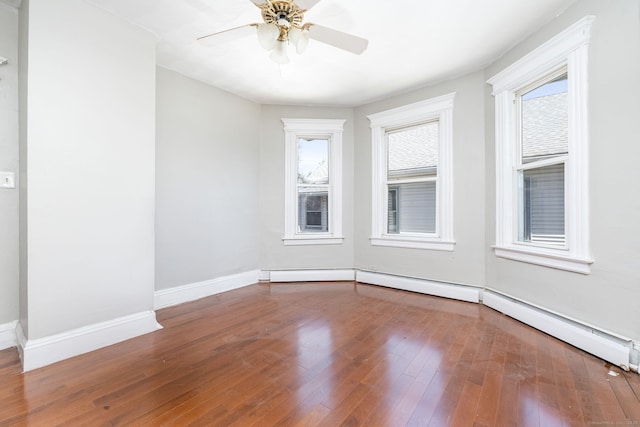 unfurnished room with plenty of natural light, wood-type flooring, ceiling fan, and baseboards