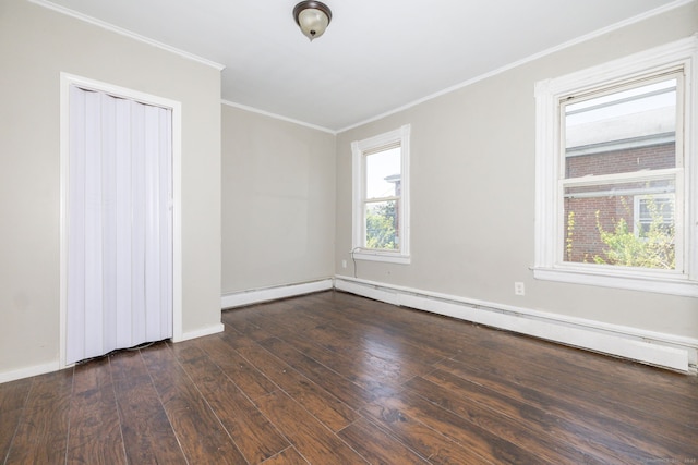 empty room with hardwood / wood-style flooring, ornamental molding, baseboards, and a baseboard radiator